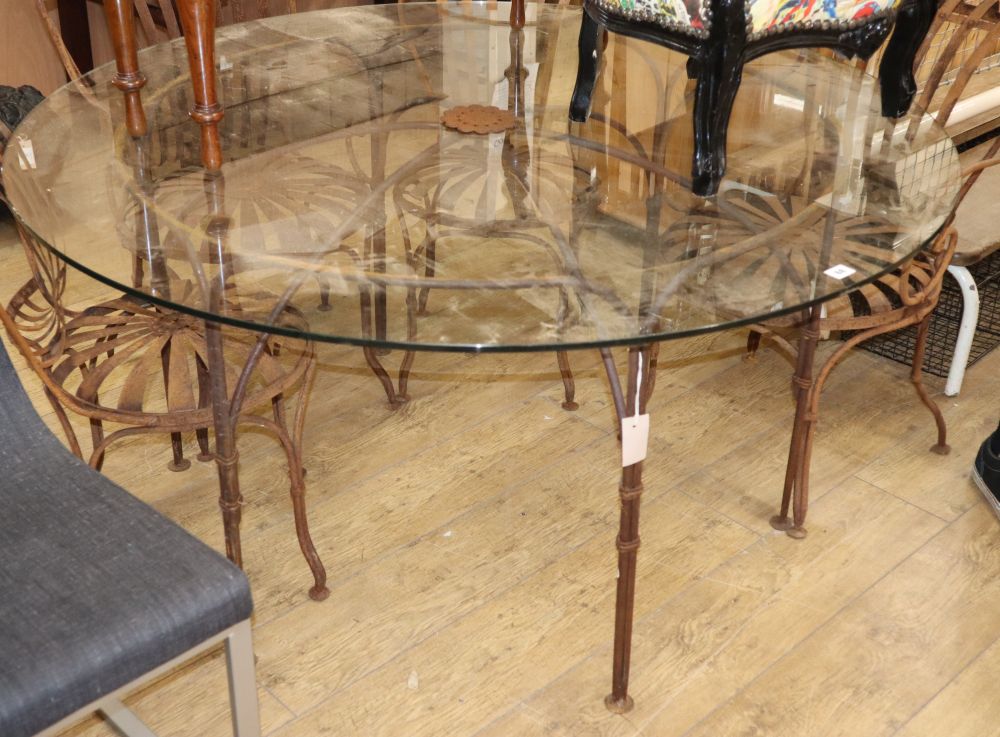 A glass-topped wrought iron garden table, Diam.137cm H.69cm